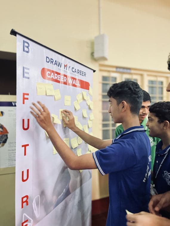 Student pinning notes on the Draw My Career Career Wall